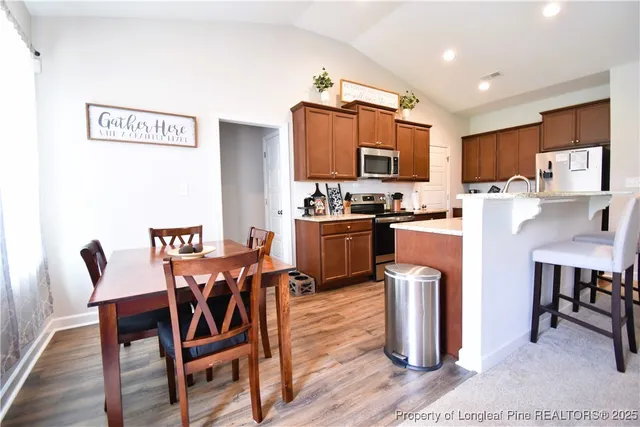 a kitchen with a dining table chairs and refrigerator