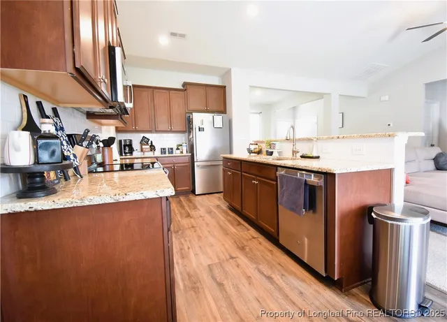 a kitchen with stainless steel appliances granite countertop a sink a stove and a refrigerator