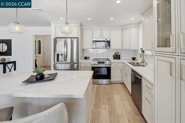 a kitchen with granite countertop a sink a counter top space stainless steel appliances and cabinets