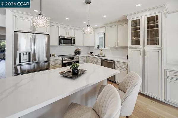 a kitchen with stainless steel appliances granite countertop a sink refrigerator and microwave