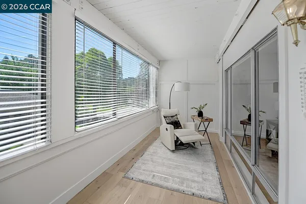 a living room with lots of white furniture and kitchen view