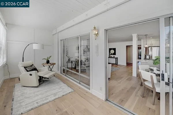 a view of a hallway with wooden floor and a living room