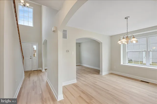 a view of a room with wooden floor staircase and a living room
