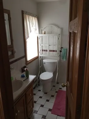 a bathroom with a toilet sink and mirror