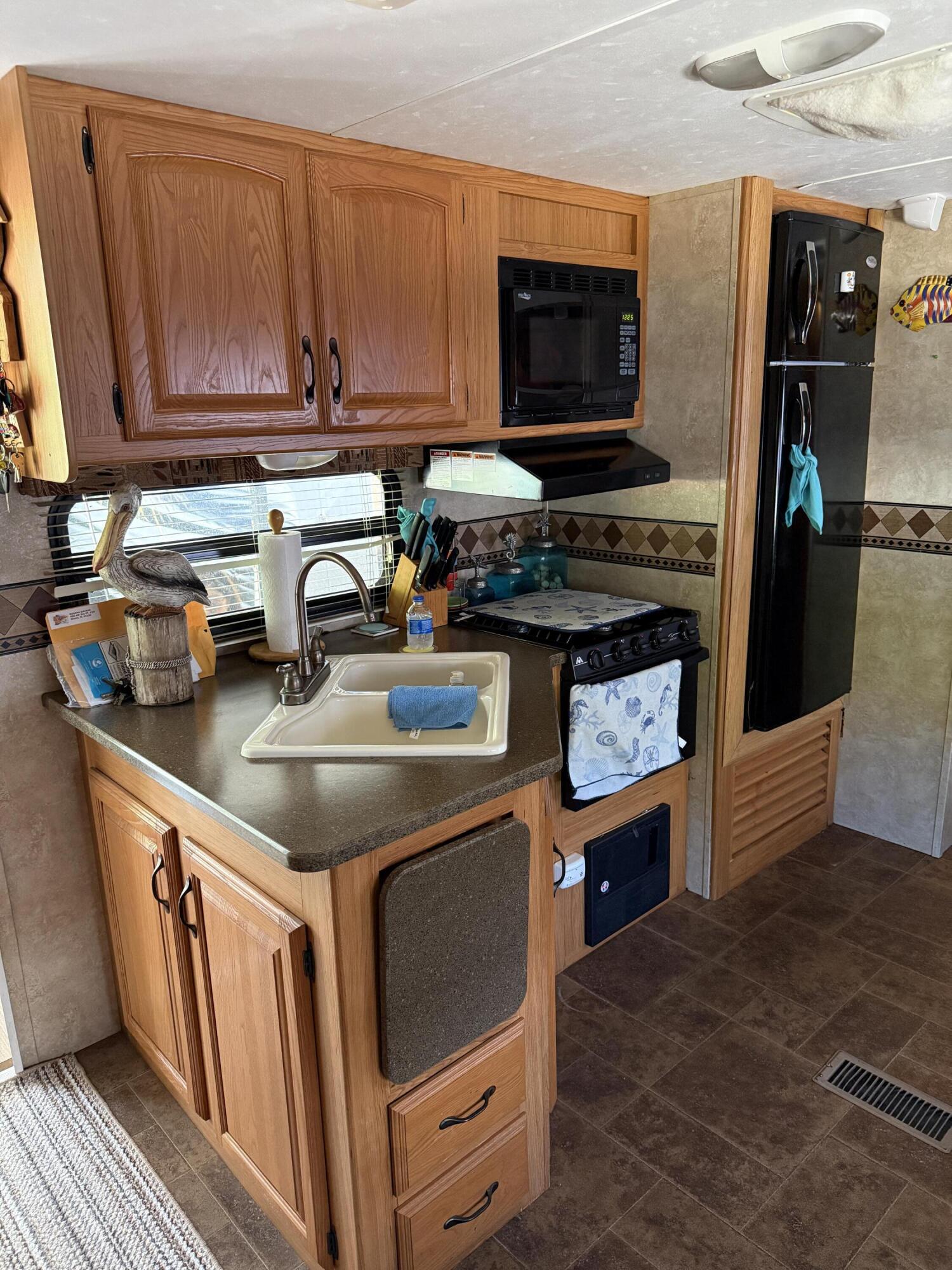 325 Calusa Street, Unit 393 Key Largo, FL 33037 - Photo 15 of 61 a kitchen with stainless steel appliances granite countertop a stove and a microwave