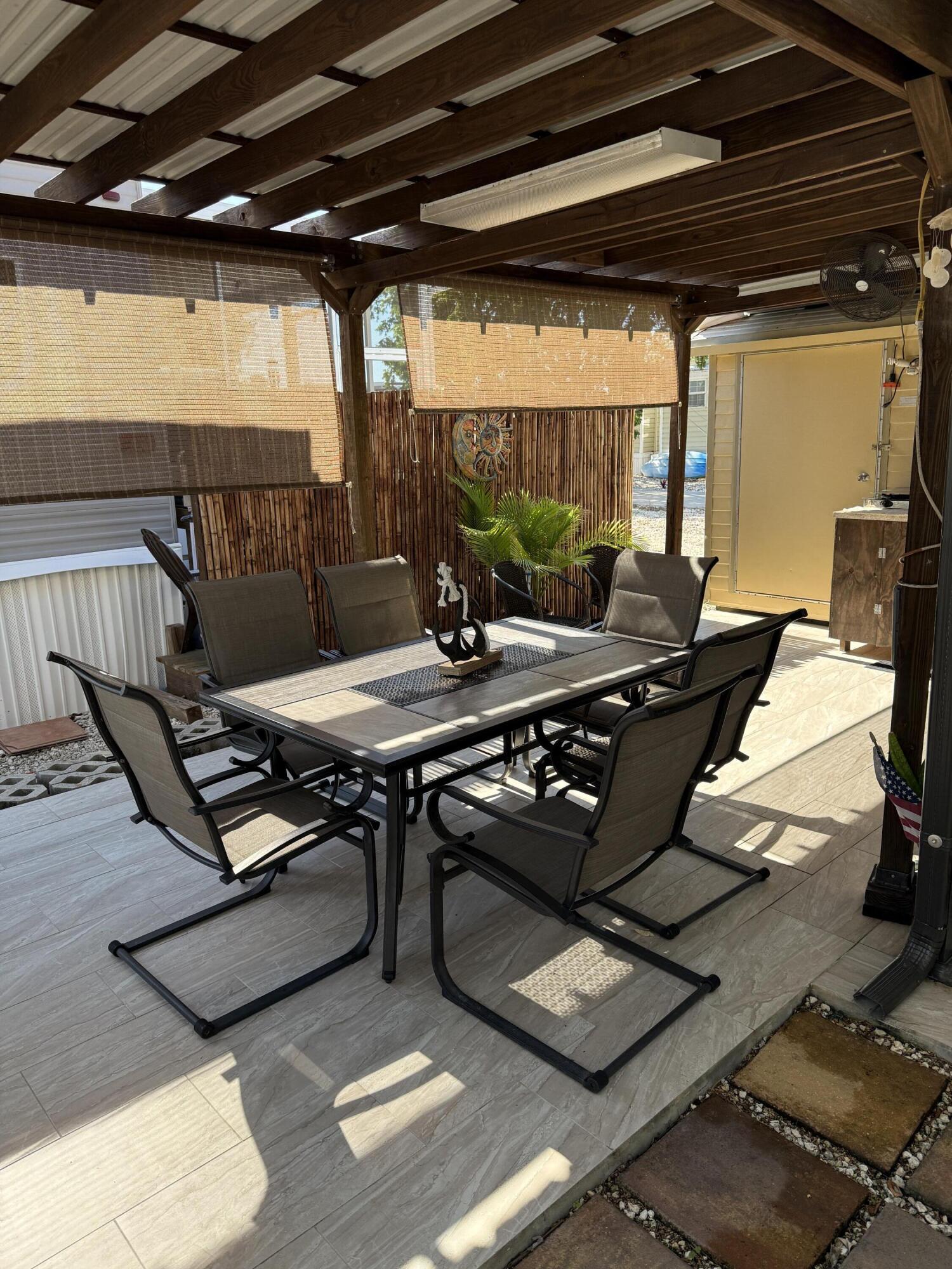 325 Calusa Street, Unit 393 Key Largo, FL 33037 - Photo 6 of 61 a view of a patio with table and chairs a barbeque