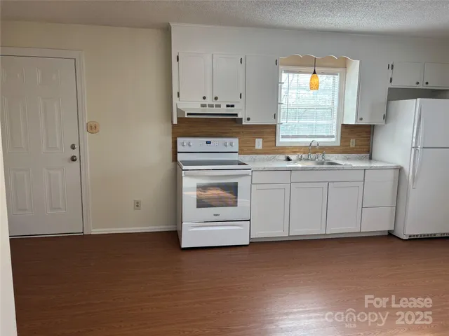 a kitchen with stainless steel appliances white cabinets and a refrigerator