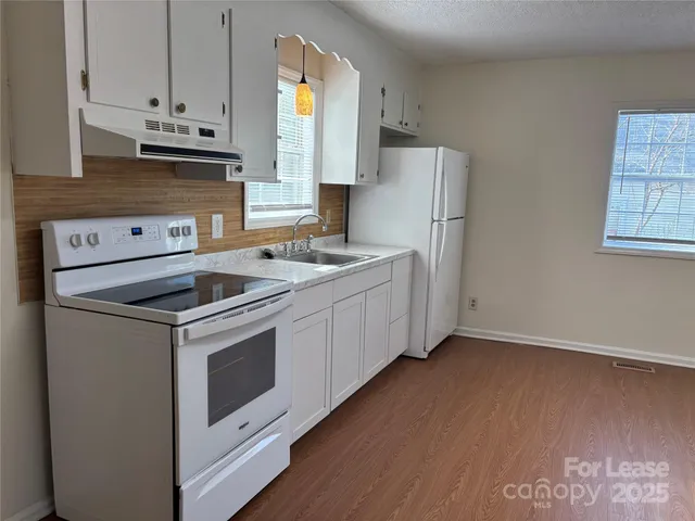 a kitchen with stainless steel appliances a stove a sink and a refrigerator