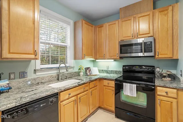 a kitchen with granite countertop sink and window