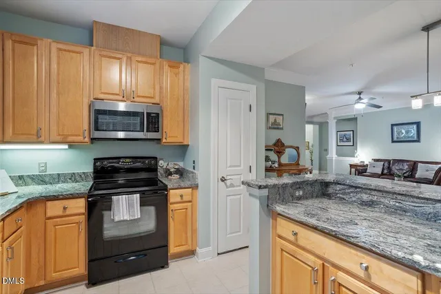 a kitchen with kitchen island granite countertop a stove and a sink