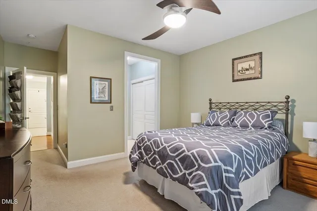 a bedroom with a bed next to a window and a chandelier