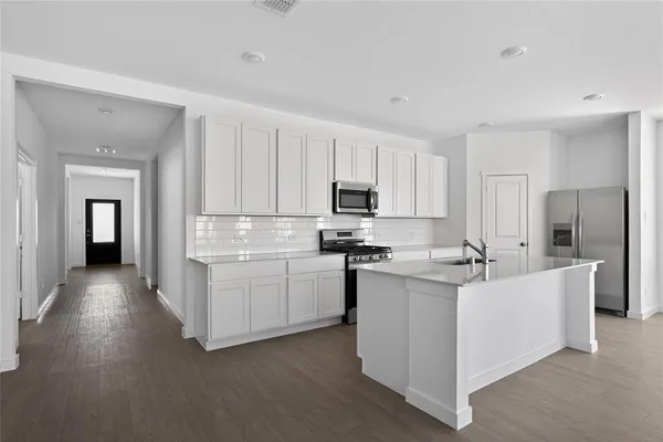 a kitchen with stainless steel appliances a sink stove and refrigerator