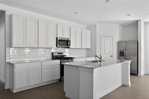 a view of a kitchen with refrigerator and windows