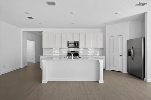 a kitchen with stainless steel appliances granite countertop a sink a stove and a refrigerator