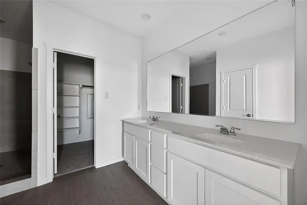 a kitchen with stainless steel appliances granite countertop a stove a refrigerator a sink and white cabinets
