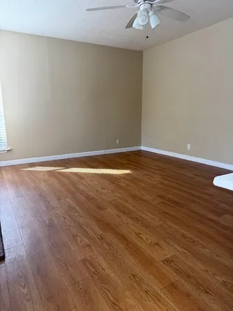 a view of an empty room with wooden floor