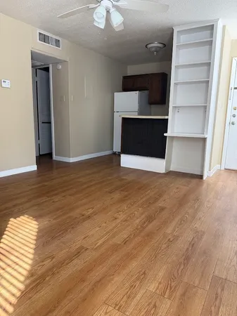 a view of empty room with wooden floor and fireplace