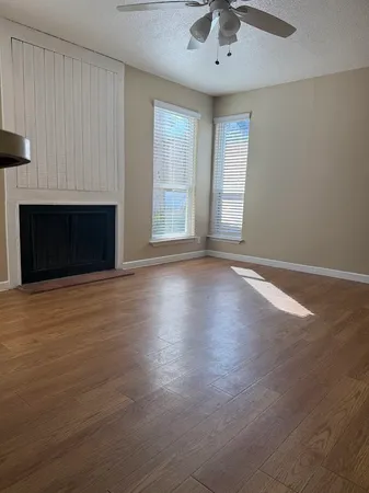 an empty room with windows and fireplace