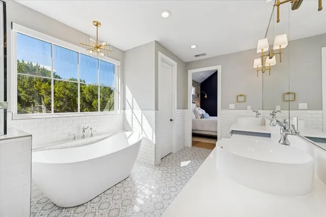 a spacious bathroom with a double vanity sink a mirror and a bathtub