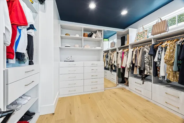 a view of walk in closet with clothes and shoes