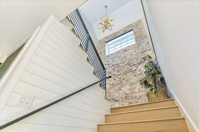 a view of a hallway with wooden floor and a bathroom