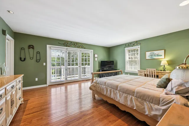 a spacious bedroom with a bed and wooden floor