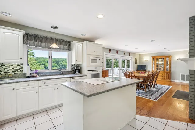 a view of a kitchen with granite countertop a sink and a stove
