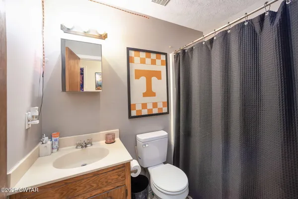 a bathroom with a sink mirror vanity and toilet