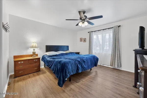 a bedroom with a large bed and a flat tv screen on dresser