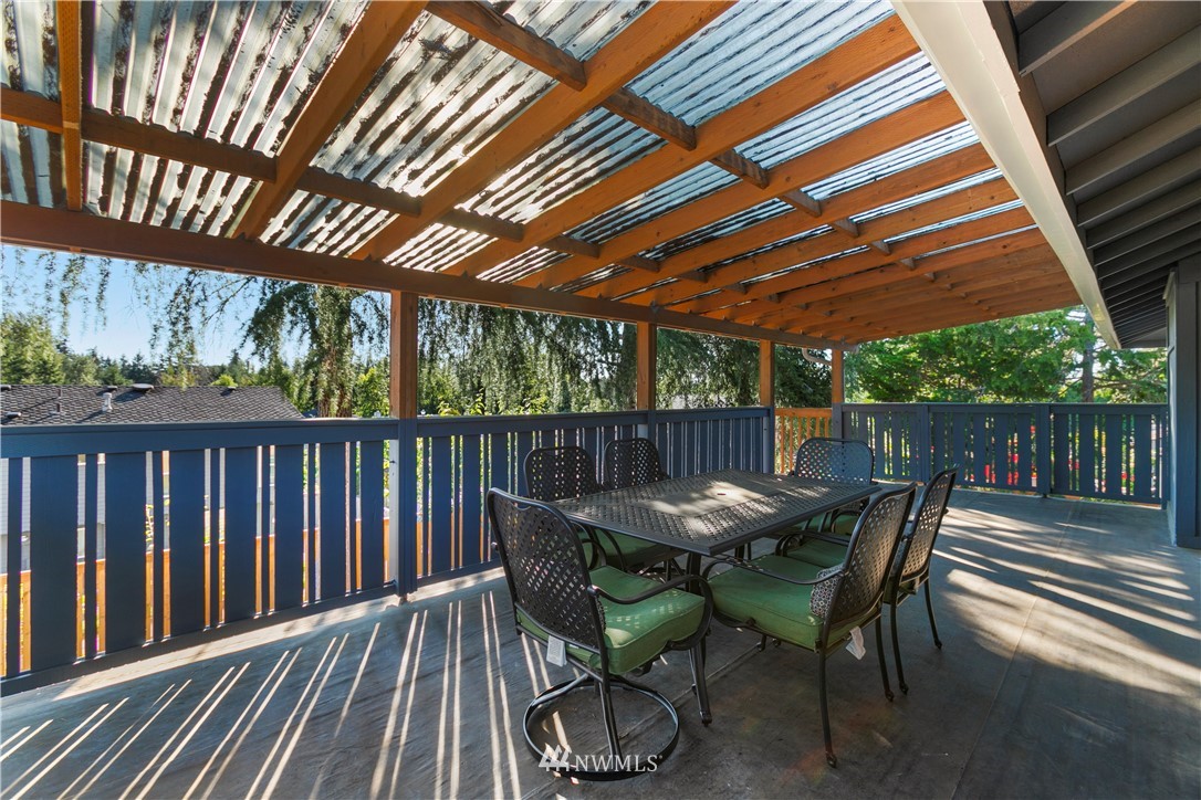 17335 159th Avenue Southeast Renton, WA 98058 - Photo 19 of 35 a view of a patio with table and chairs with wooden floor and fence