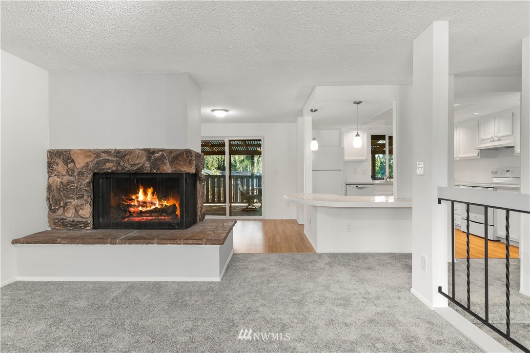 17335 159th Avenue Southeast Renton, WA 98058 - Photo 3 of 35 a open kitchen with a fireplace and a large window