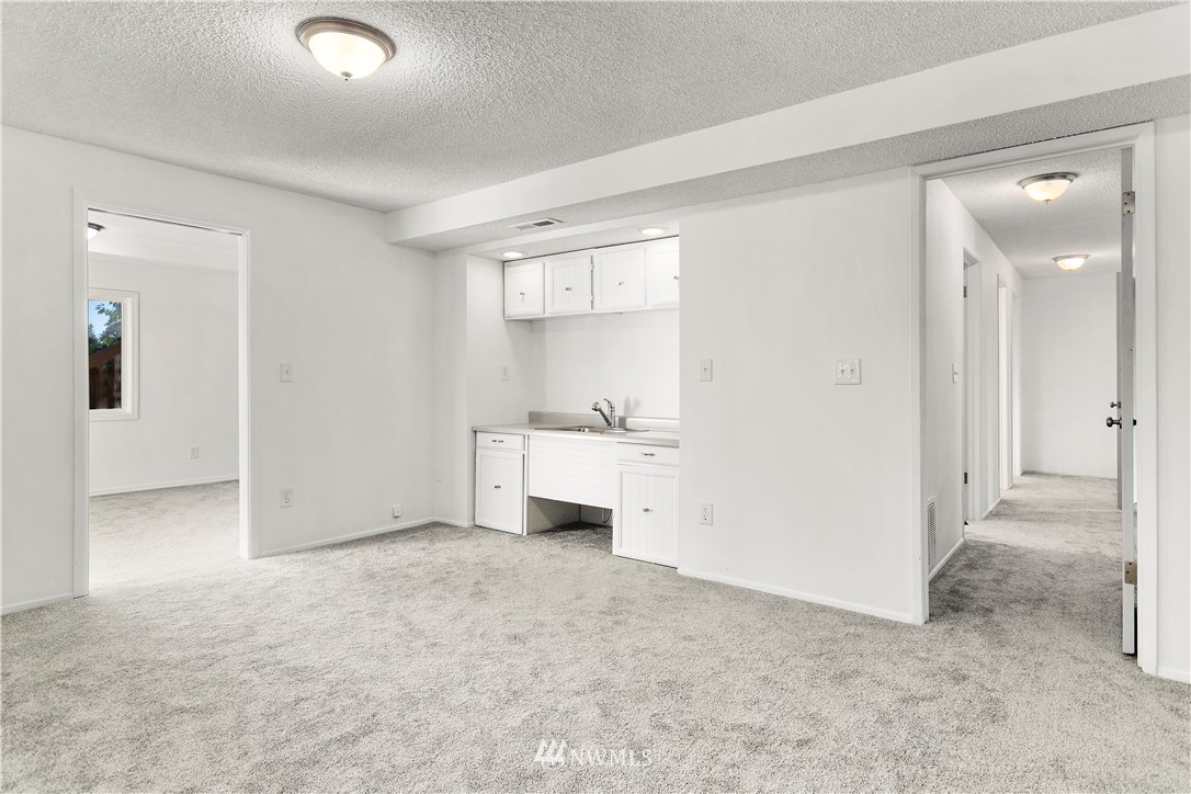 17335 159th Avenue Southeast Renton, WA 98058 - Photo 24 of 35 an empty room with a fireplace and mirror