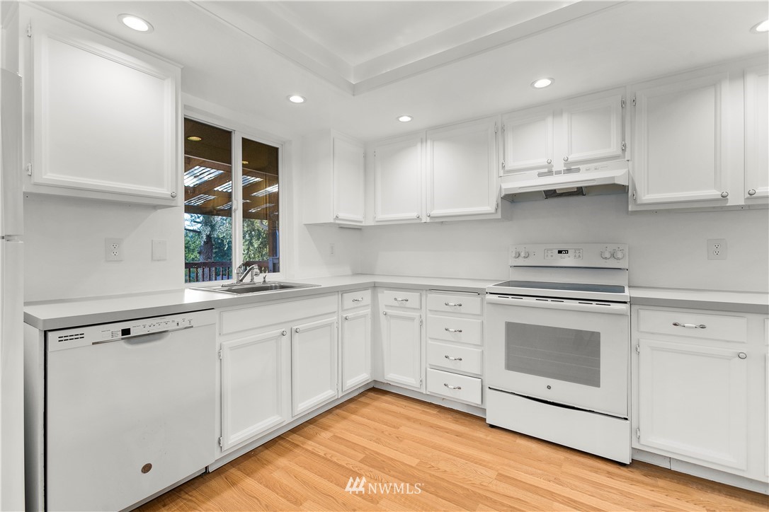 17335 159th Avenue Southeast Renton, WA 98058 - Photo 8 of 35 a kitchen with white cabinets stainless steel appliances and sink
