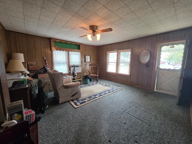 a living room with furniture a flat screen tv and gym equipment