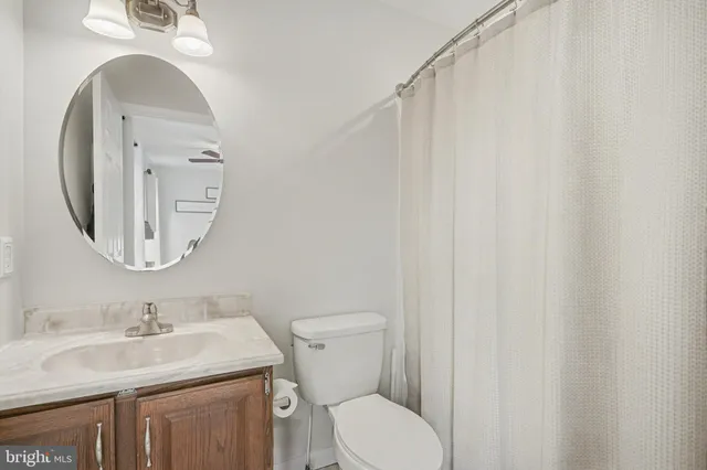 a bathroom with a granite countertop sink toilet and a mirror