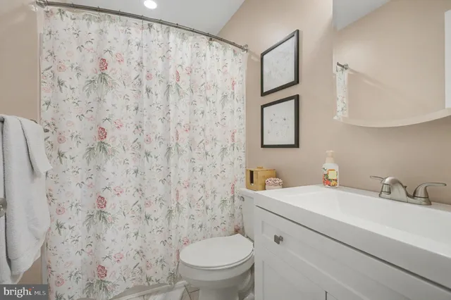a bathroom with a toilet sink vanity and mirror