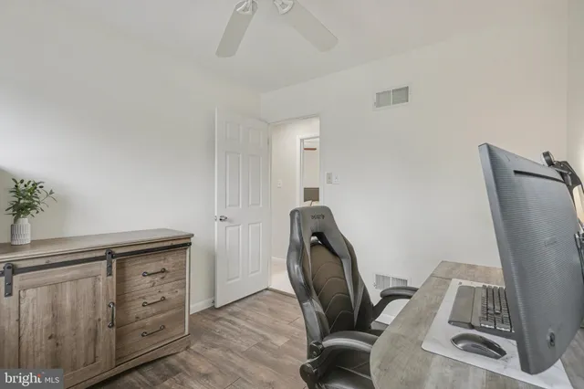 a view of a workspace with furniture and wooden floor