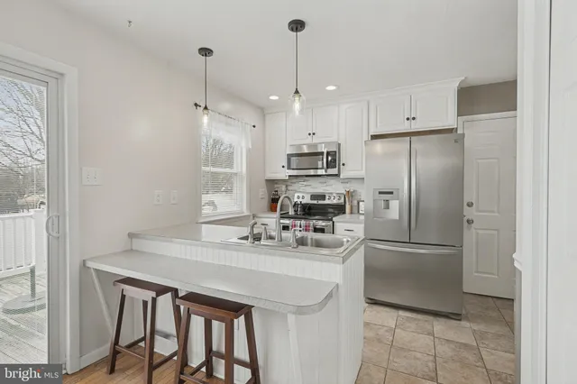 a kitchen with stainless steel appliances a refrigerator a sink a stove a microwave and island