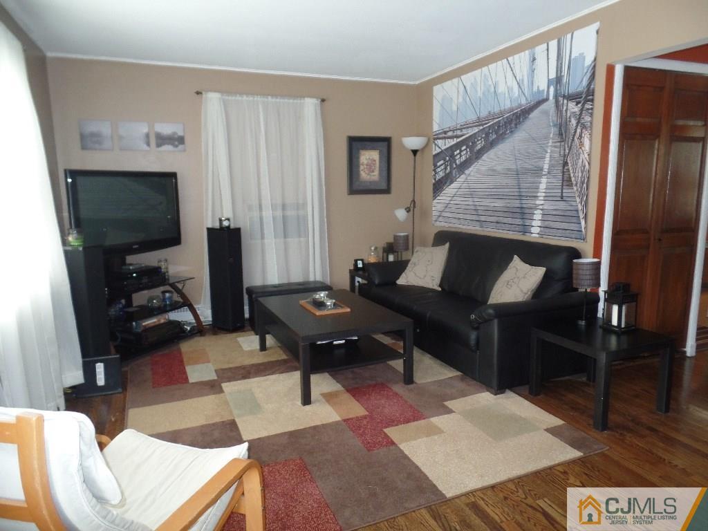 189 Midfield Road Colonia, NJ 07067 - Photo 4 of 16 a living room with furniture a rug and a flat screen tv