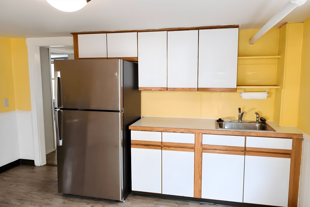 305 Rindge Avenue, Unit 1 Cambridge, MA 02140 - Photo 3 of 7 a kitchen with stainless steel appliances a refrigerator sink and cabinets
