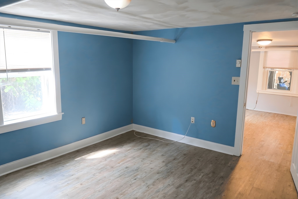 305 Rindge Avenue, Unit 1 Cambridge, MA 02140 - Photo 5 of 7 an empty room with wooden floor and windows