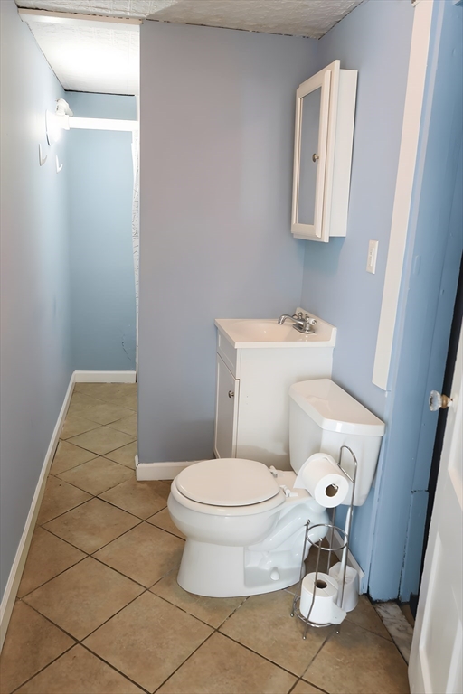 305 Rindge Avenue, Unit 1 Cambridge, MA 02140 - Photo 7 of 7 a white toilet sitting next to a bathroom sink and vanity