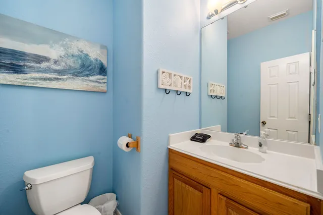 a bathroom with a sink mirror vanity and toilet