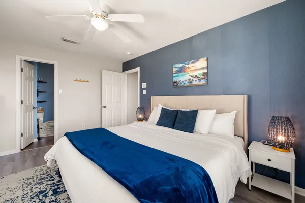 a bedroom with a large bed and a chandelier