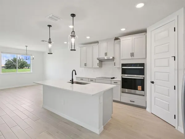 a kitchen with kitchen island white cabinets and appliances