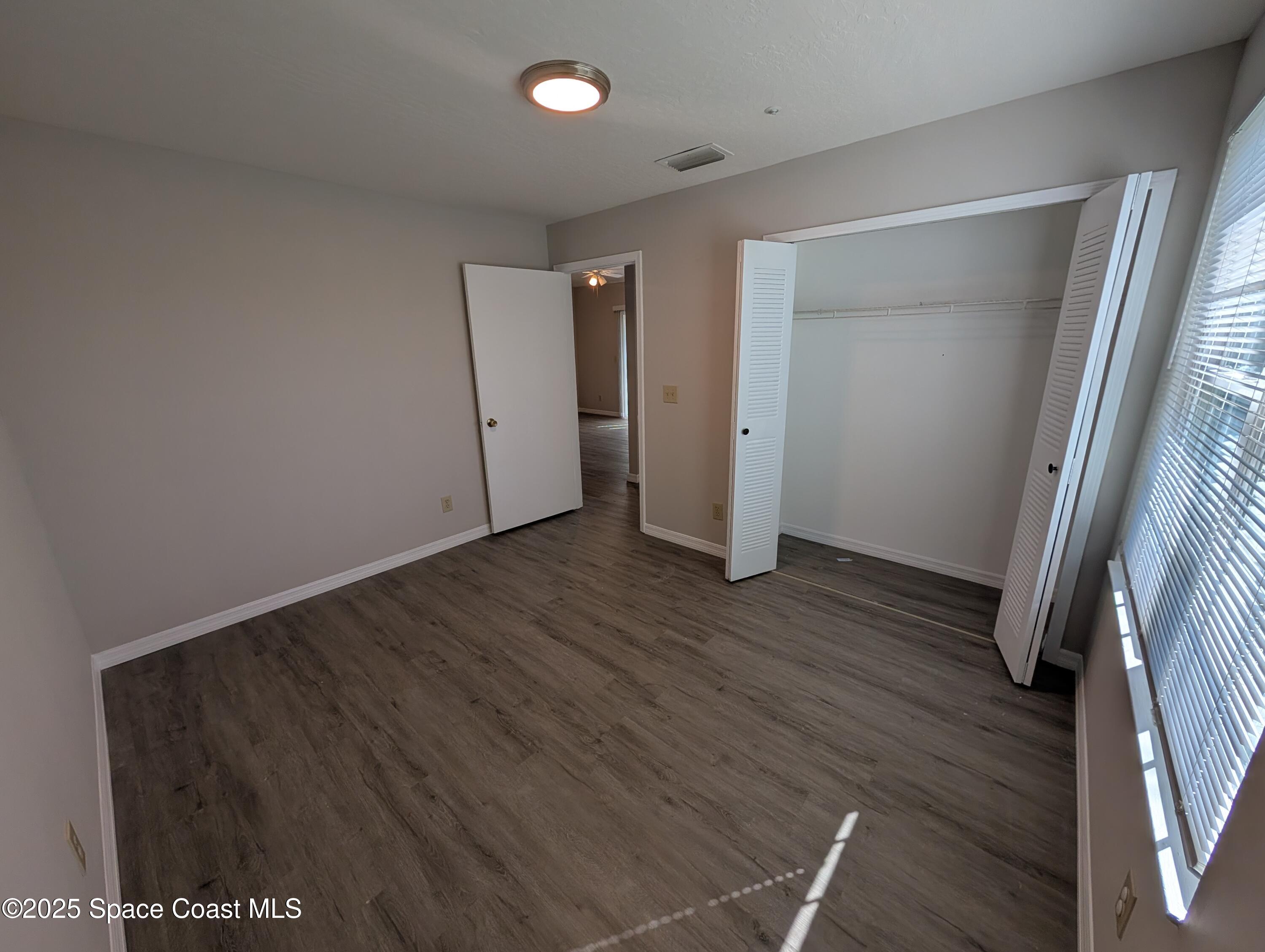 7667 North Wickham Road, Unit 1209 Melbourne, FL 32940 - Photo 13 of 23 a view of hallway with wooden floor