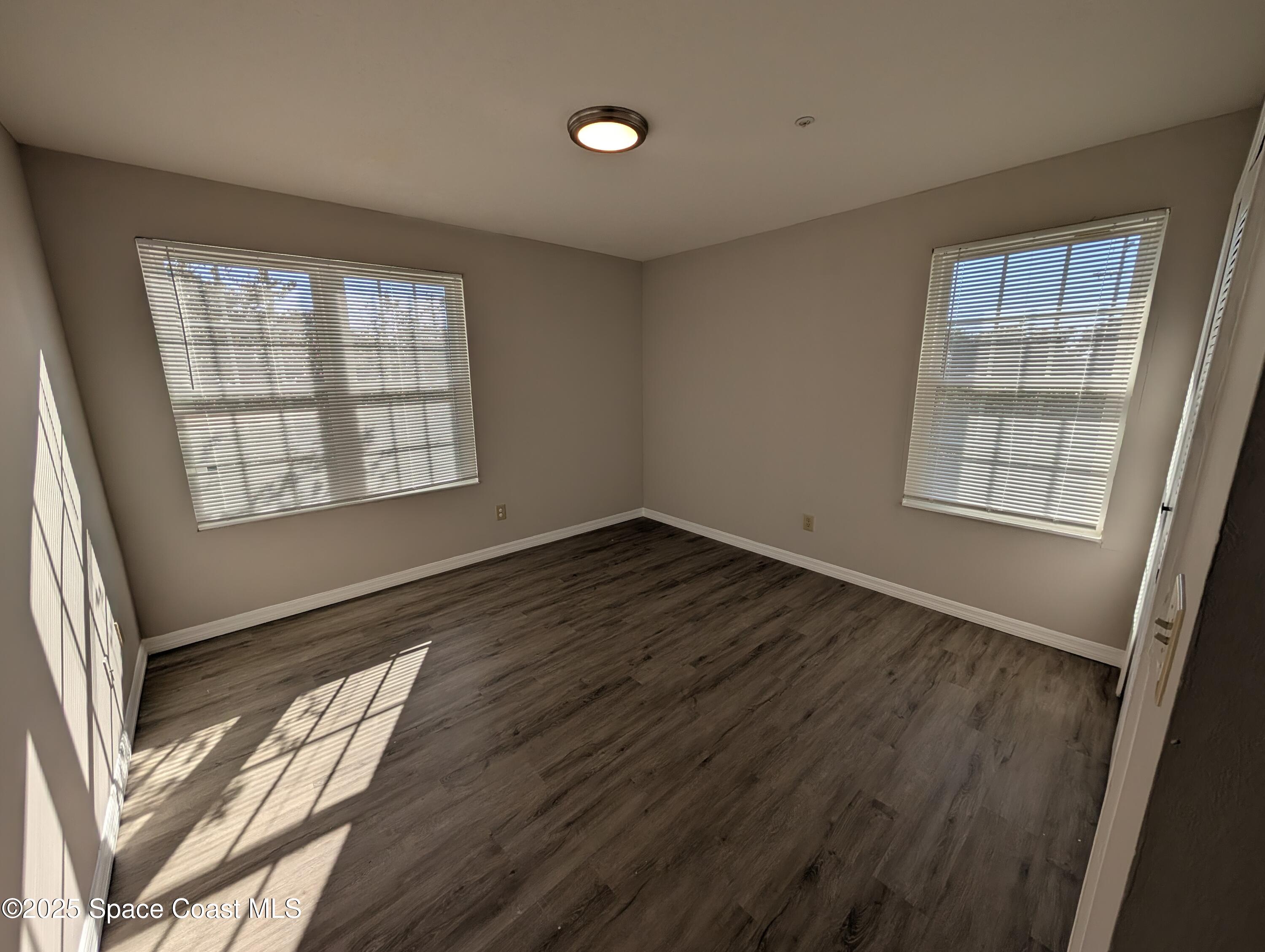 7667 North Wickham Road, Unit 1209 Melbourne, FL 32940 - Photo 14 of 23 a view of an empty room with wooden floor and a window