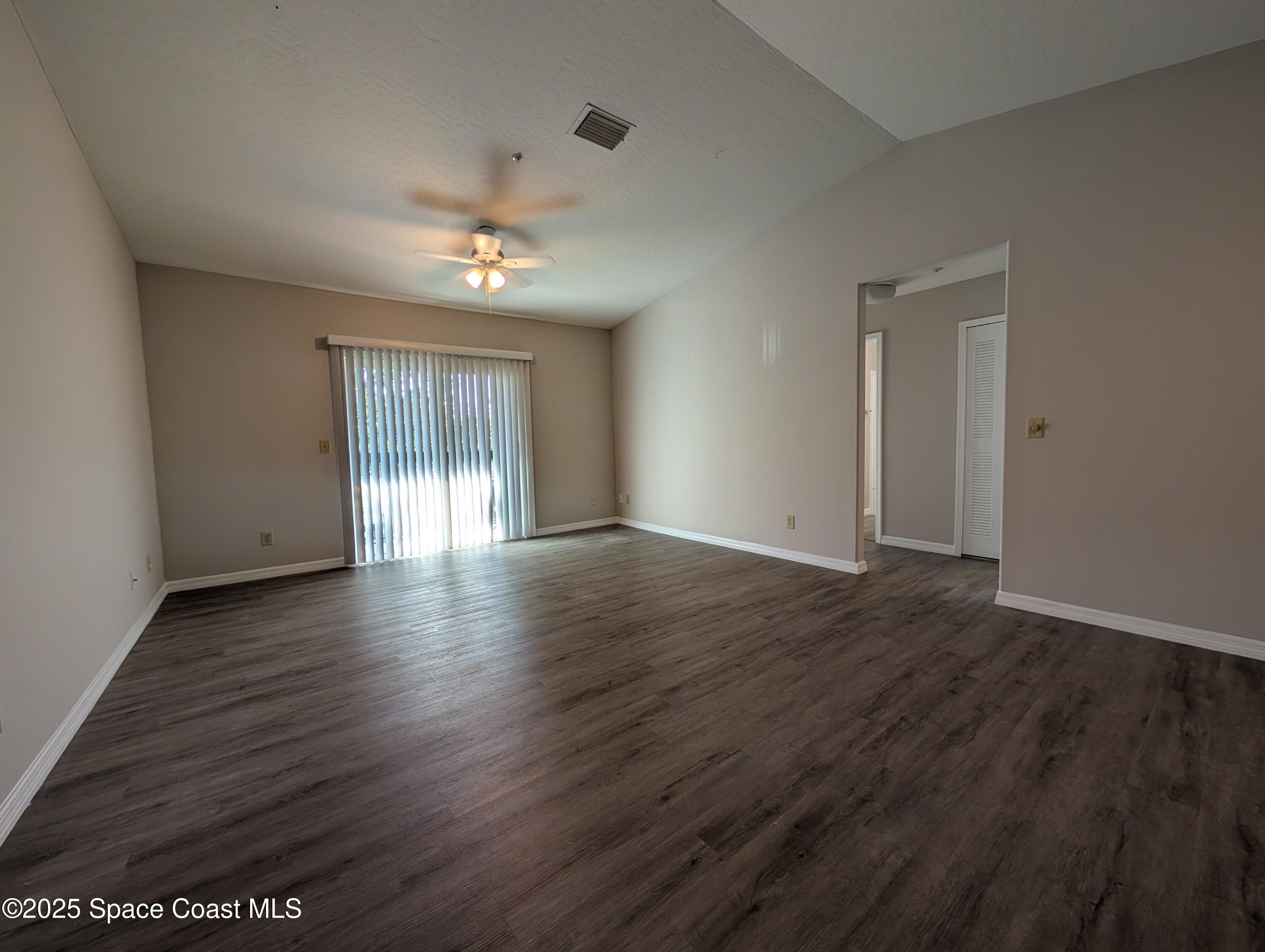 7667 North Wickham Road, Unit 1209 Melbourne, FL 32940 - Photo 2 of 23 a view of an empty room with wooden floor and a window