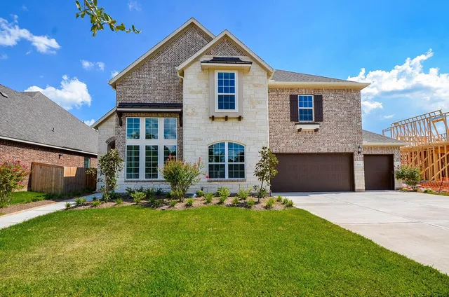 a front view of a house with a yard and outdoor seating