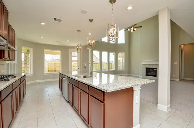 a kitchen with granite countertop a sink stove and refrigerator